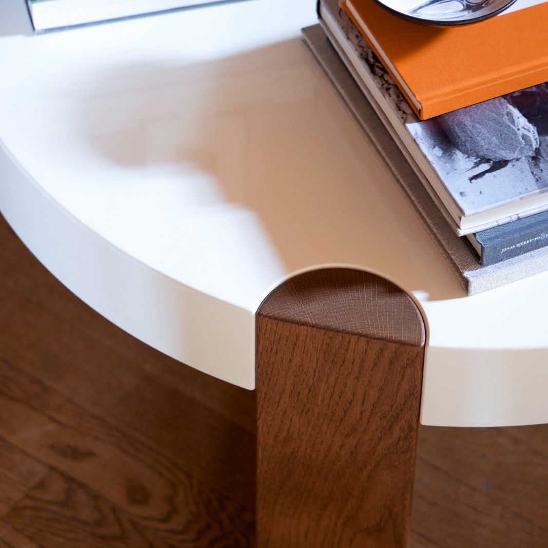 Detail of the FER Coffee Table's oak leg with books on the white top