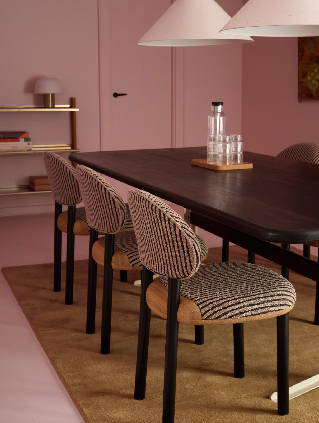 MAG Dining Chairs with striped upholstery at a dark dining table in a pink dining room