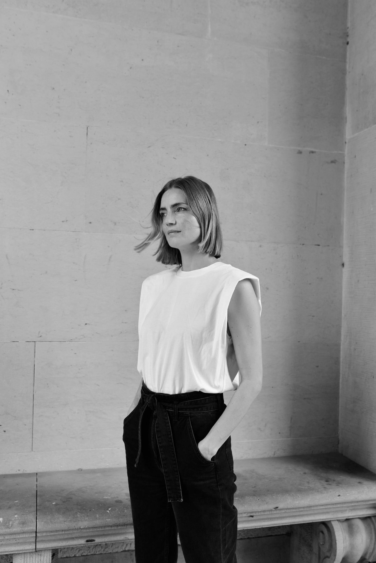 Jessica Vedel photographed in black and white against a stone wall