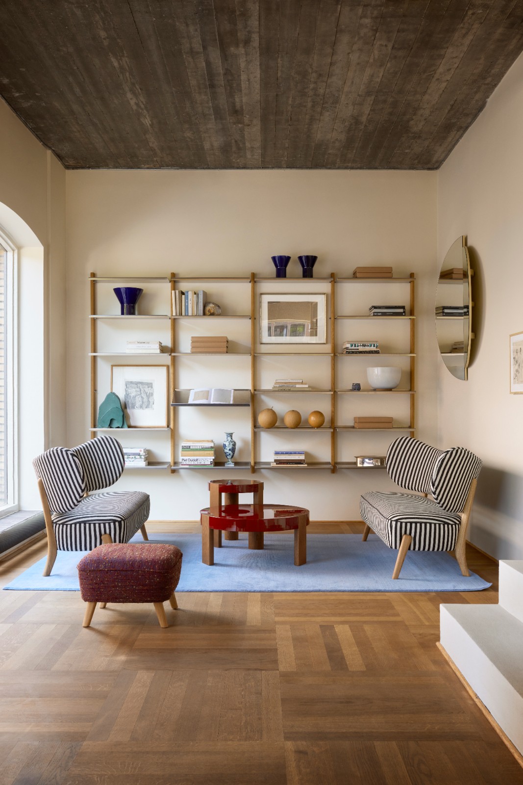 Large MOD Shelving System in oak and aluminium styled with books and art in a living room with striped armchairs