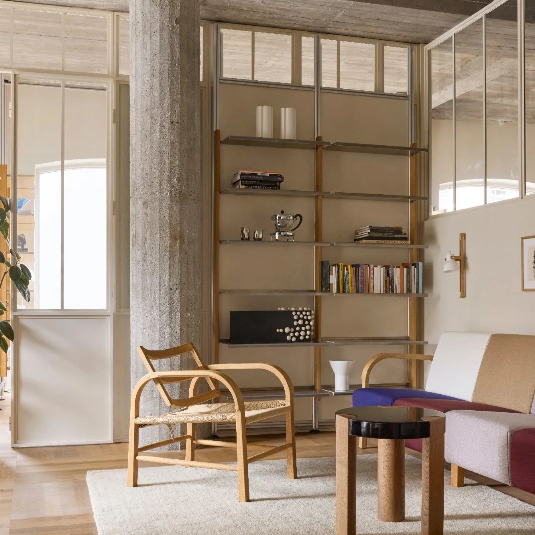 FER Side Table with black top in front of a MOD shelving wall and a wooden lounge chair