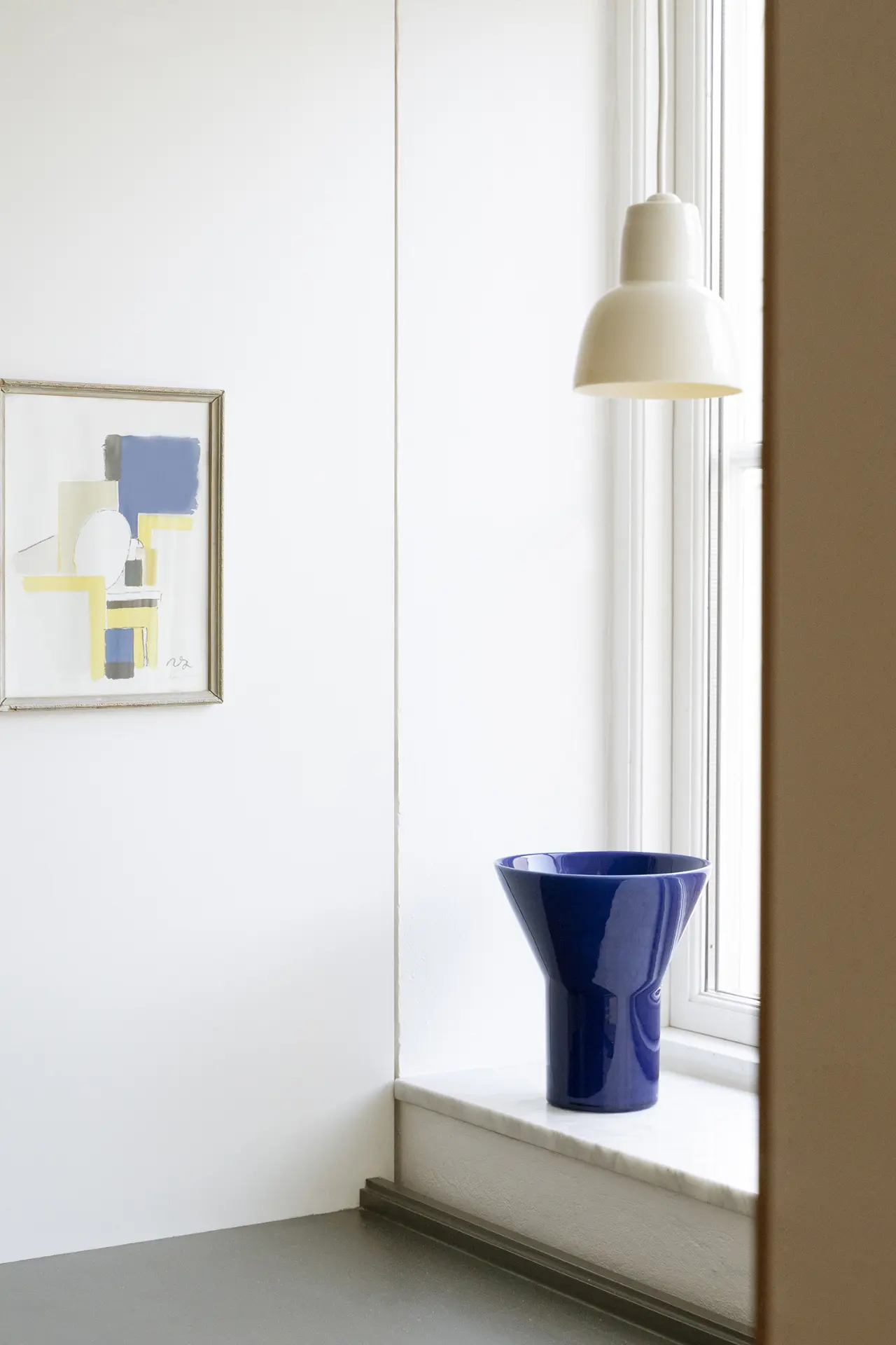 Blue KYO Vase Large on a windowsill beneath a pendant lamp