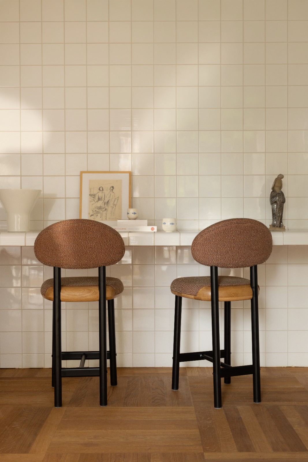Two MAG Counter Stools in brown upholstery at a white tiled counter
