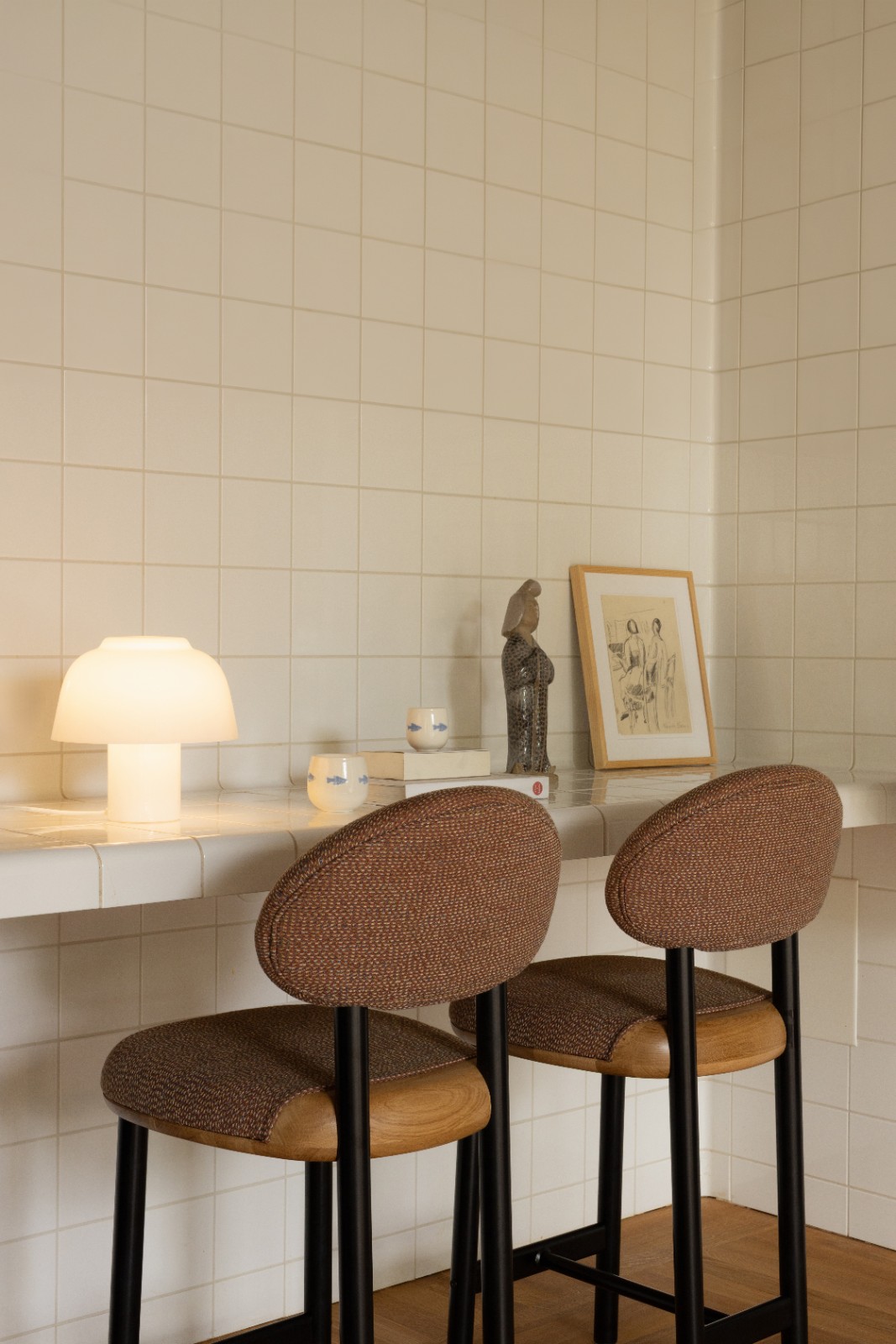 Two MAG Counter Stools in brown upholstery at a tiled counter beside a glowing mushroom lamp