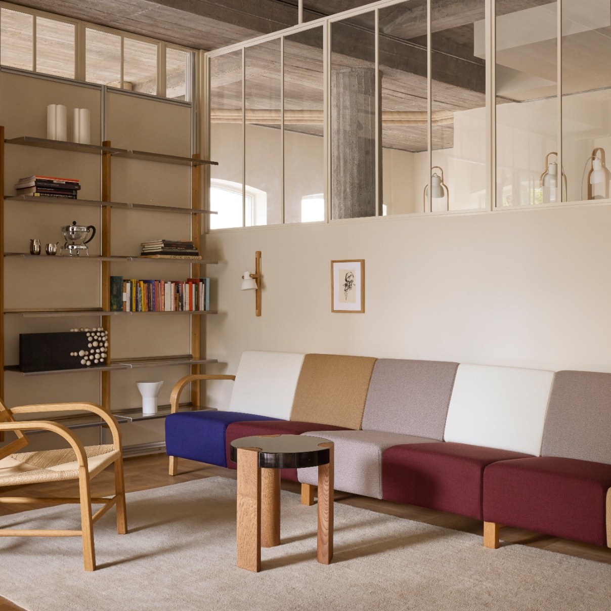 FER Side Table with black top beside a colourful modular sofa in a concrete loft