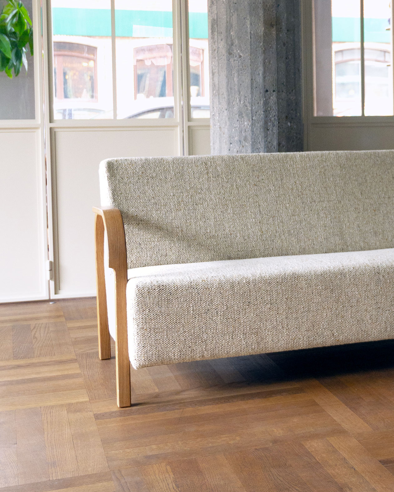 ARCH 2 Seater Sofa in green woven upholstery against white cabinet doors