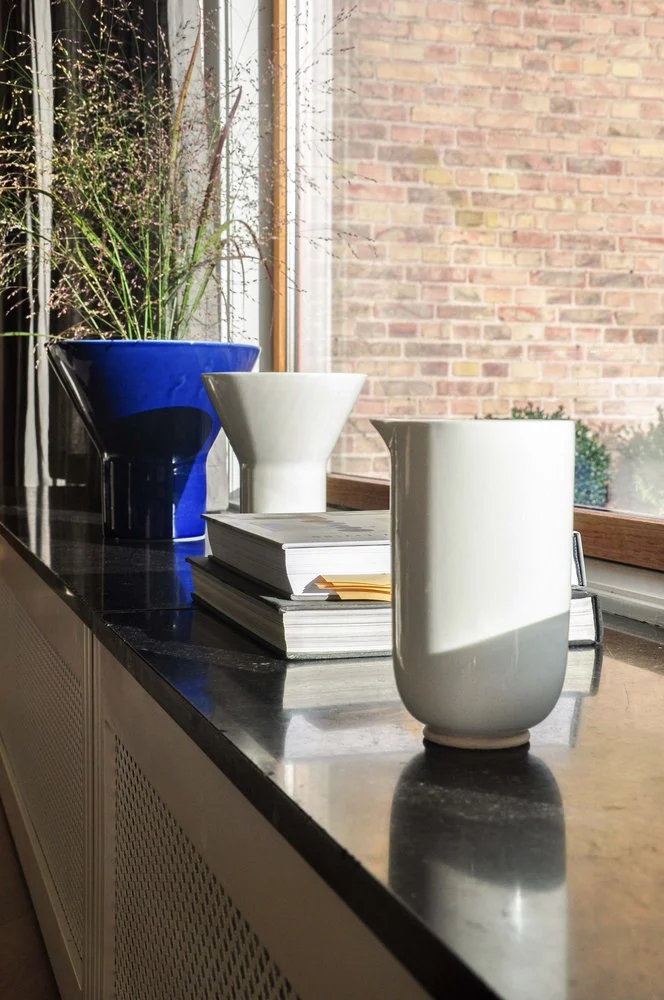 Mazo white pitcher on a windowsill beside blue and white vases