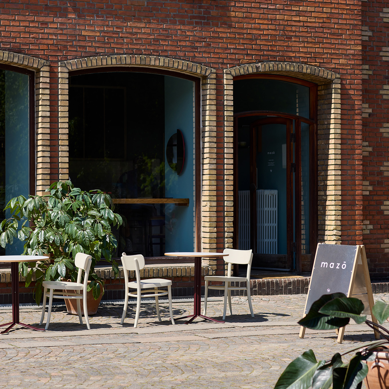 Mazo showroom entrance in Dronningegården, Copenhagen, with chairs outside the brick facade