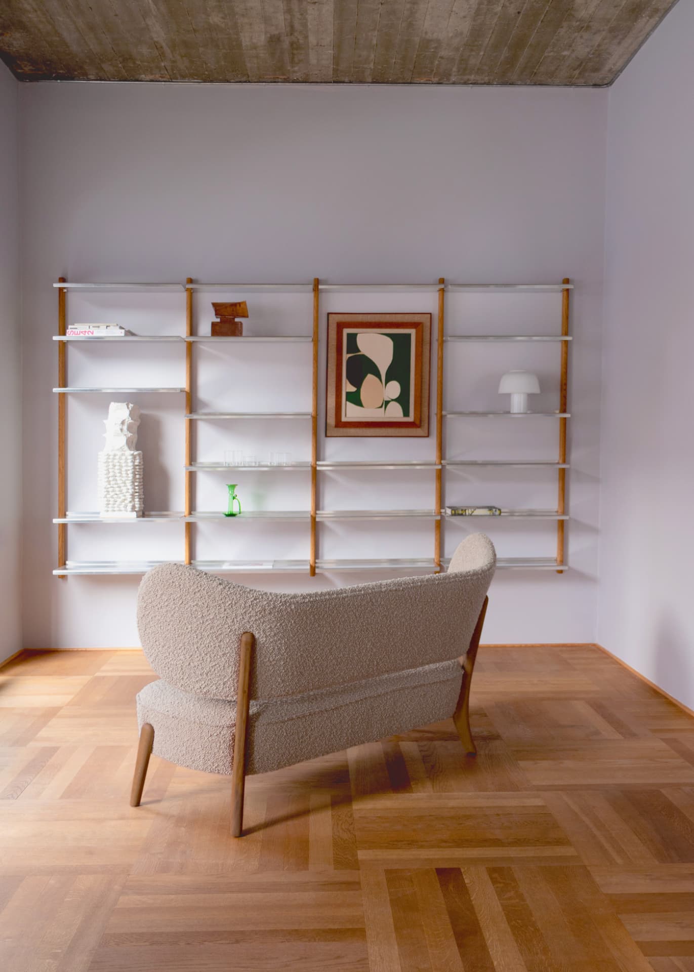 TMBO Sofa in beige bouclé seen from behind in front of a MOD Shelving System