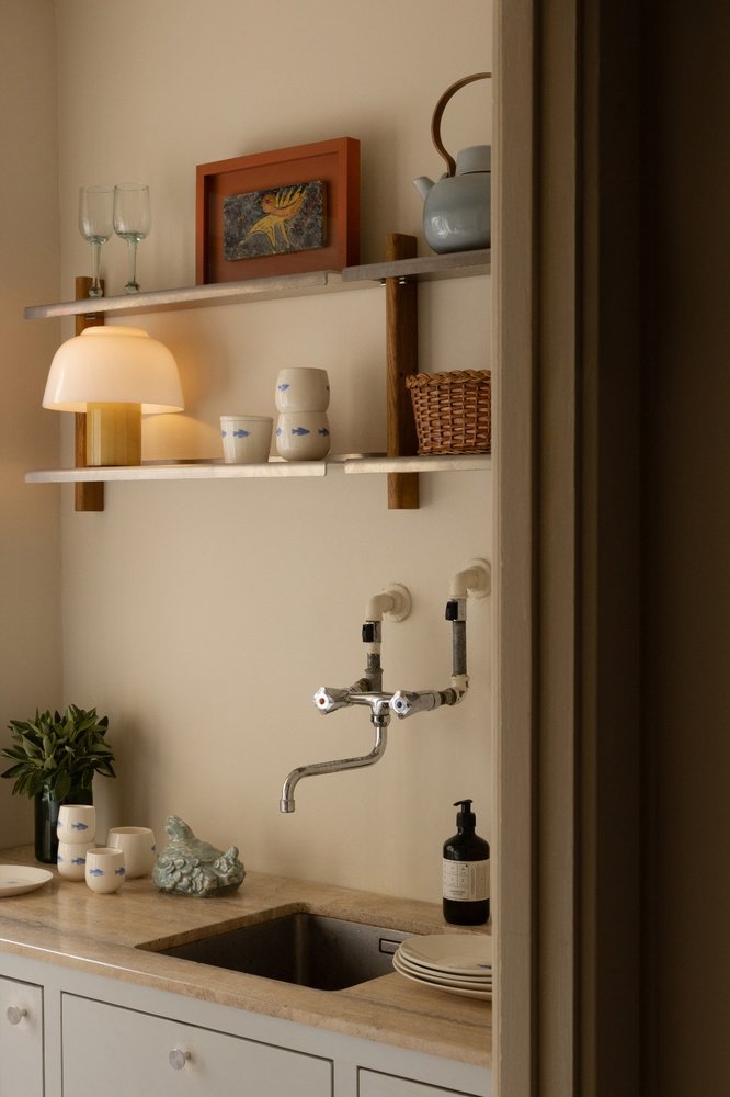 YUKI Lamp glowing on a kitchen shelf with cups, baskets and framed artwork