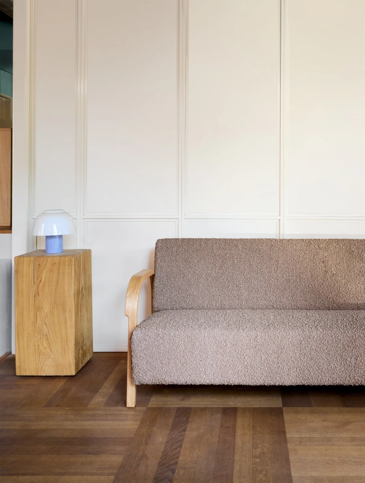 ARCH 2 Seater Sofa in brown bouclé beside an oak side table with a blue lamp
