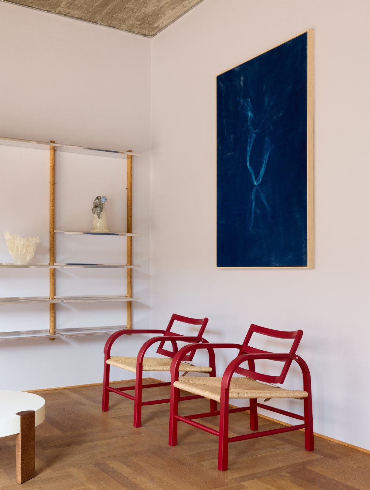 Pair of red chairs beneath a large blue artwork