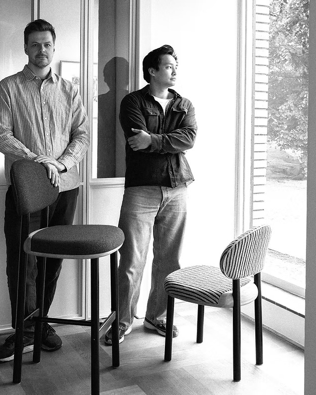 The MAG chair designers standing beside the MAG barstool and chair in a daylight studio