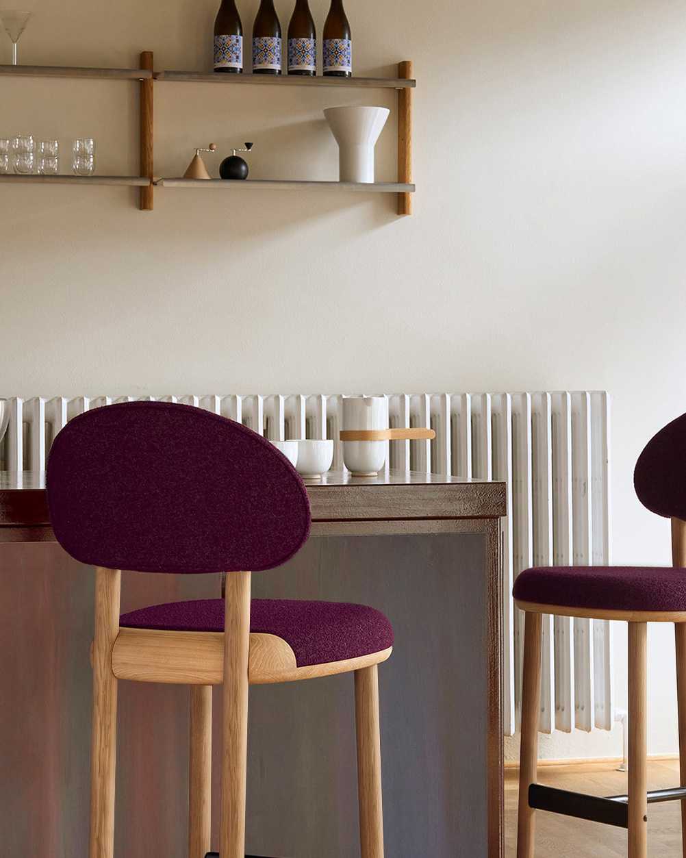 Two MAG Counter Chairs in burgundy upholstery at a counter with a radiator and wall shelves behind