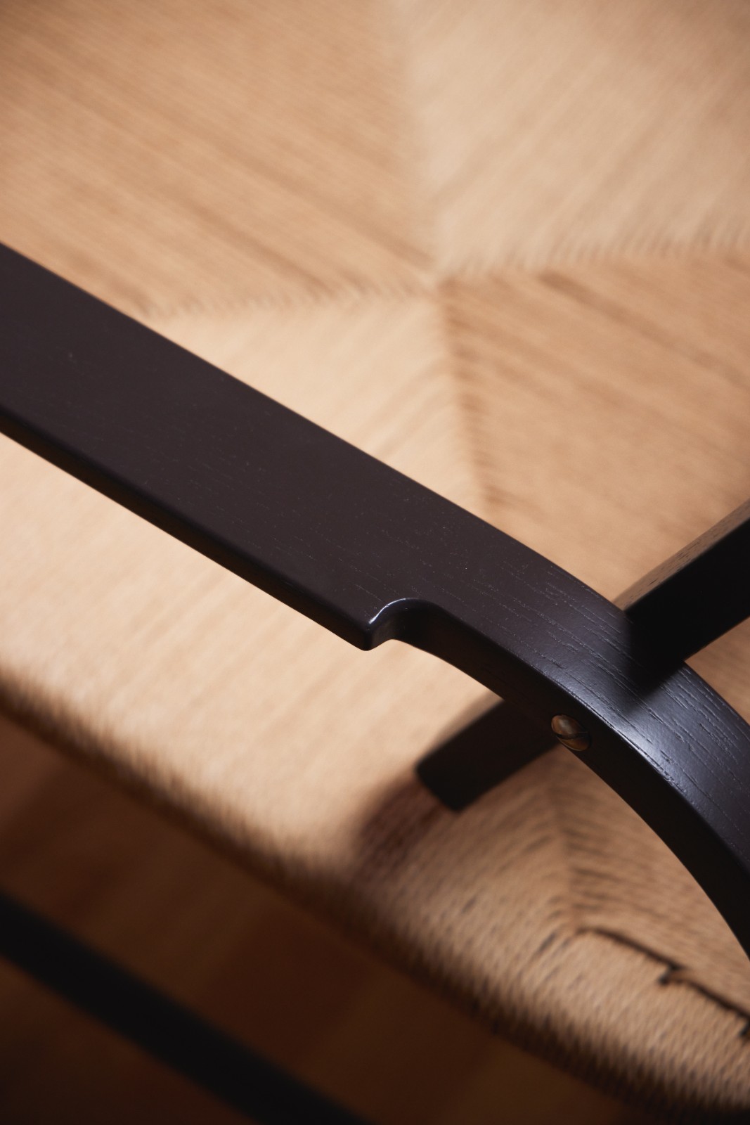 Detail of the dark stained frame and woven rush seat