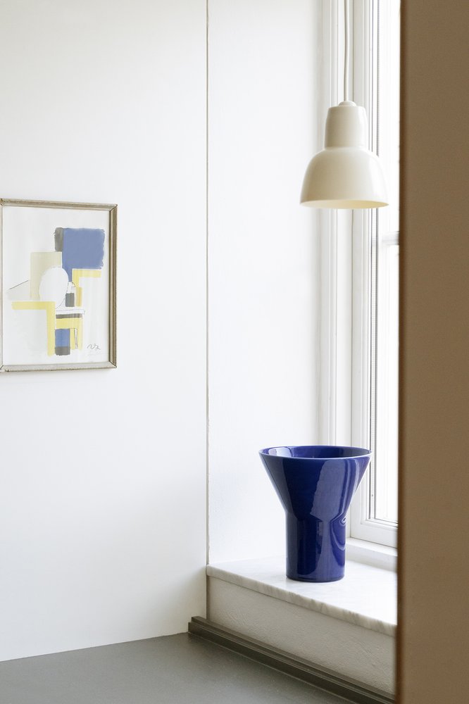 16PLUS Pendant in white beside a window with a blue vase on the sill