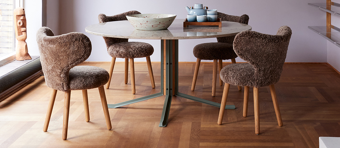 WNG chairs in brown bouclé around a round dining table in the Mazo showroom