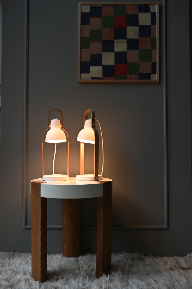 Two 16PLUS Table Lamps glowing on a round oak side table
